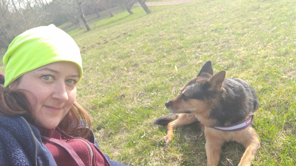 Meine Hündin Biza und ich sitzen auf einer Wiese.